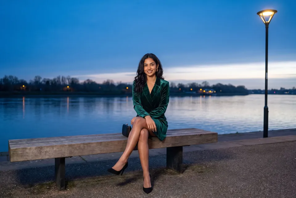 A woman on a riverside bench at dusk