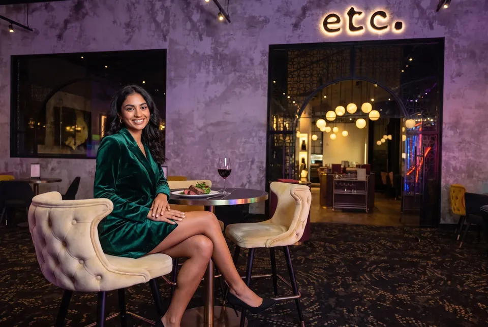 A woman at a table outside the etc. steakhouse